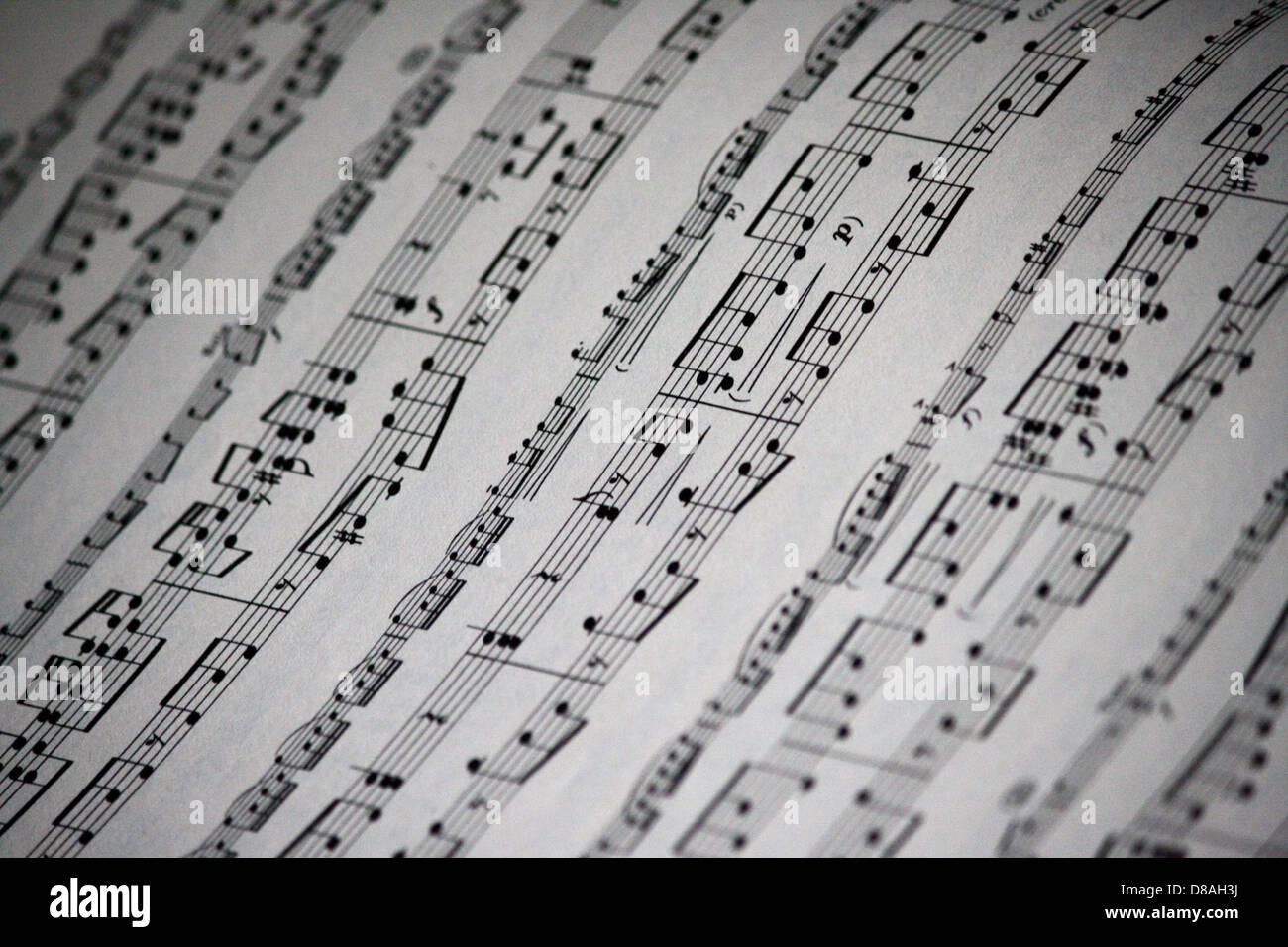A close-up view of sheet music reveals intricate musical notes and ...