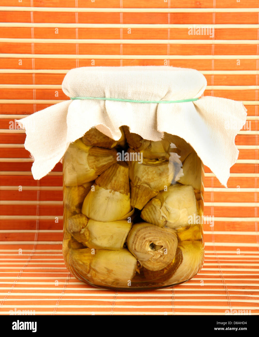 Jar artichokes in oil on orange background Stock Photo Alamy