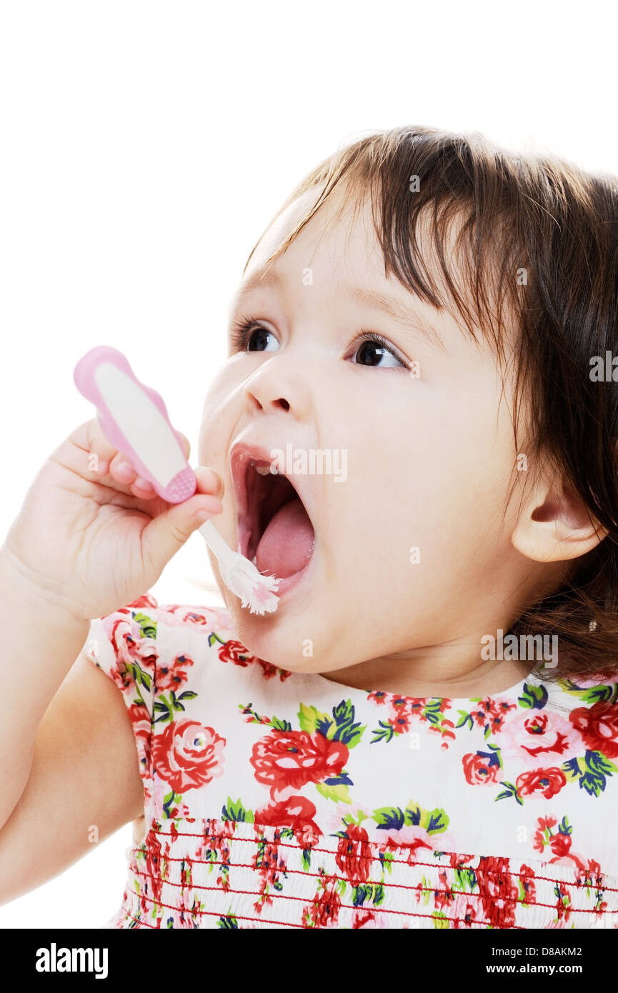 Little girl brushing teeth with pink toothbrush Stock Photo