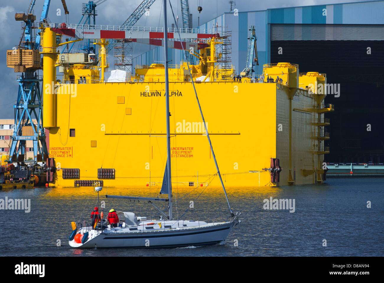 A sailing vessel goes past the offshore platform HelWin alpha in front of the shipbuilding hall