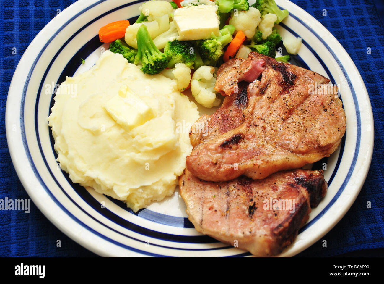 Grilled Pork Chop Dinner with Side Dishes Stock Photo