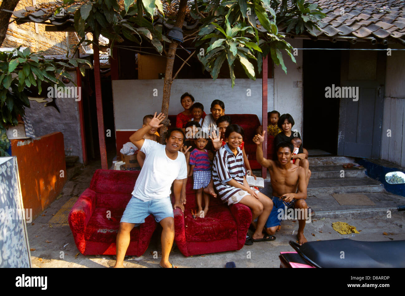 Extended Indonesian family gathered outside a traditional home