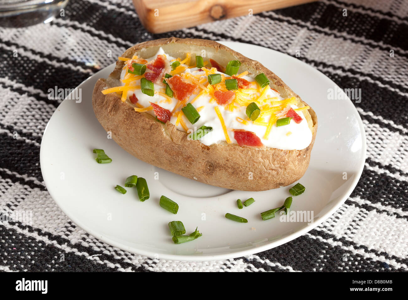 Hot Baked Potato with chives, cheese, and sour cream Stock Photo