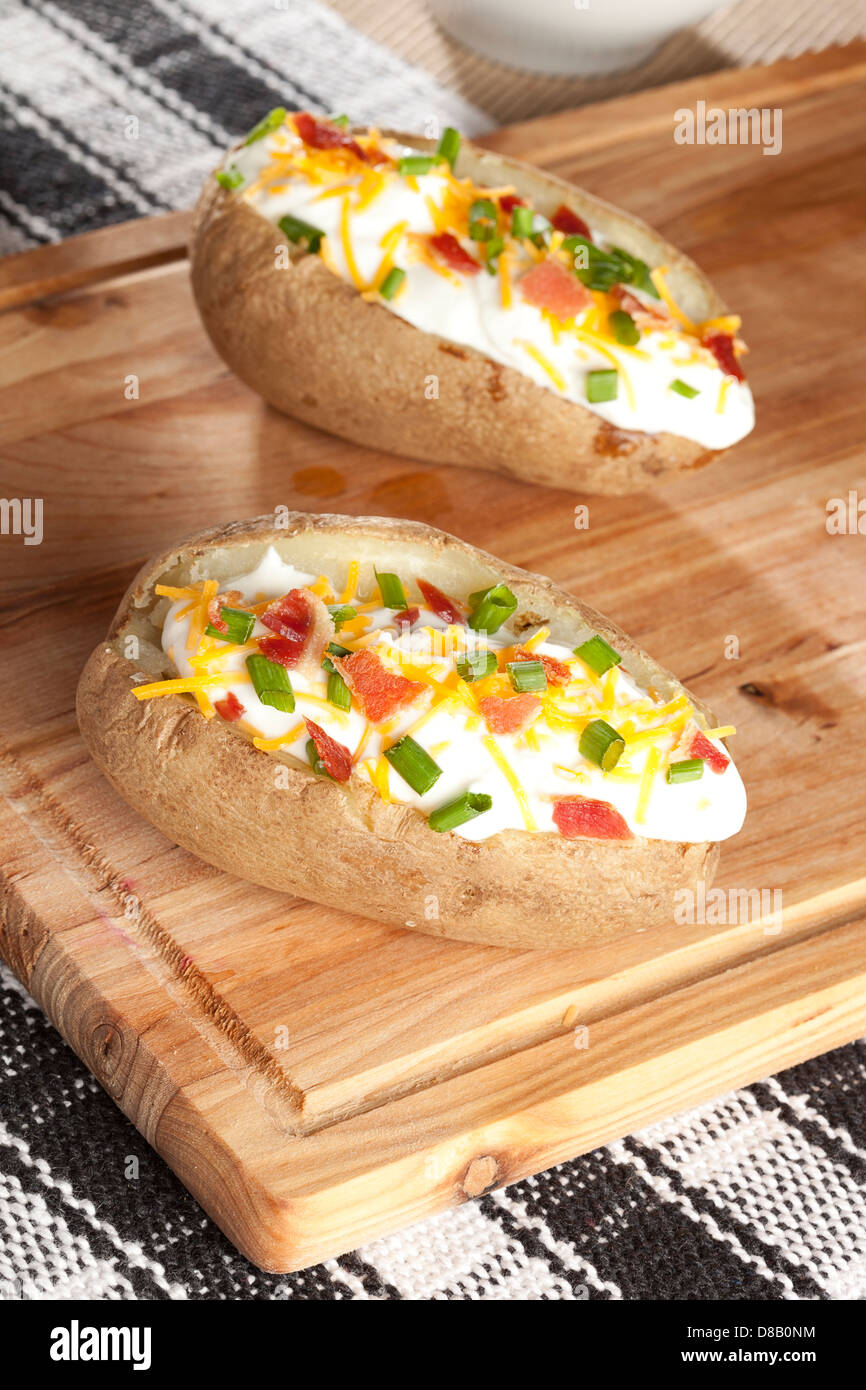 Hot Baked Potato with chives, cheese, and sour cream Stock Photo