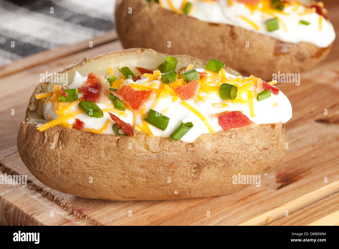 Hot Baked Potato with chives, cheese, and sour cream Stock Photo