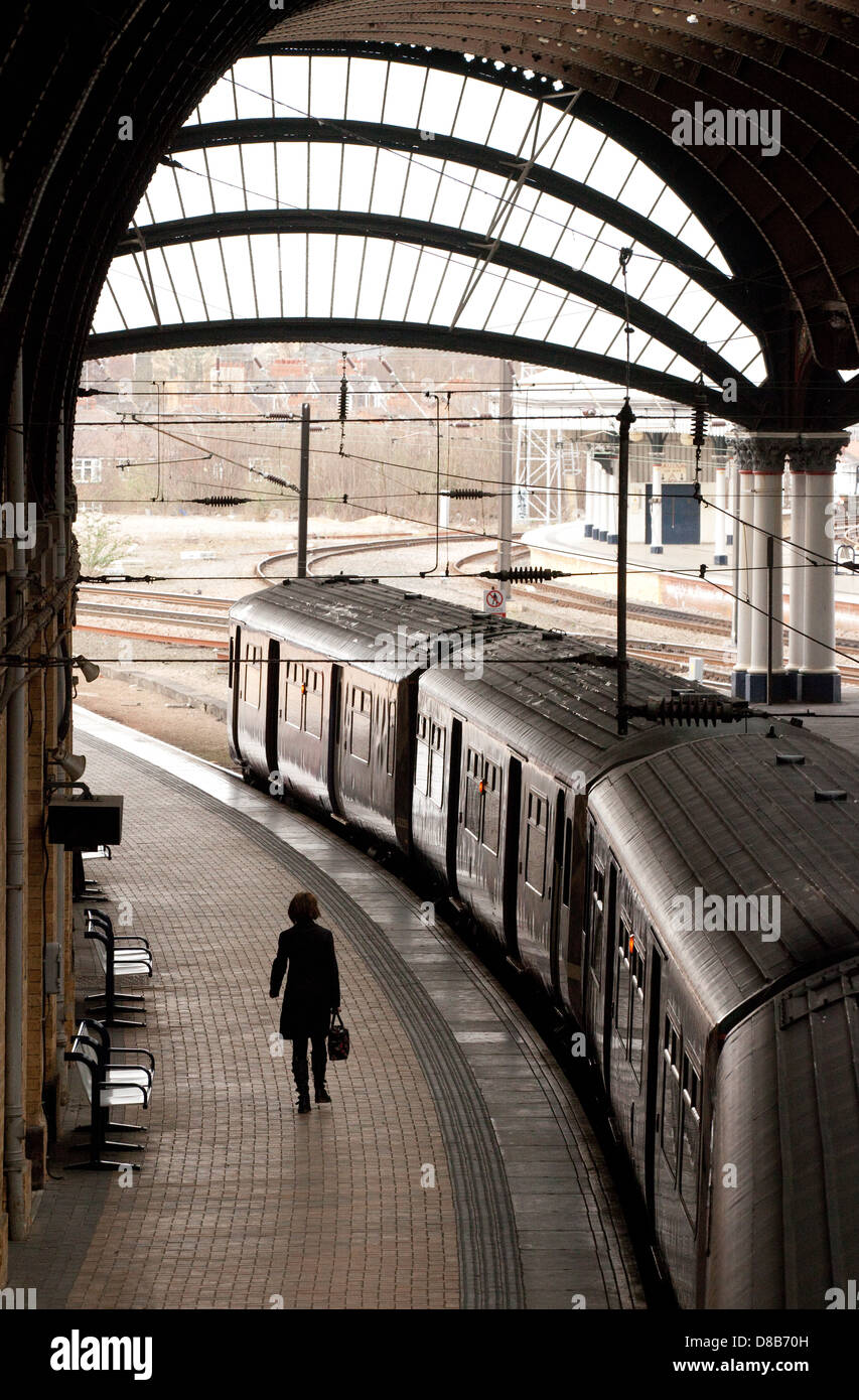 A woman on the platform catching a train, York Railway Station, York, Yorkshire UK Stock Photo