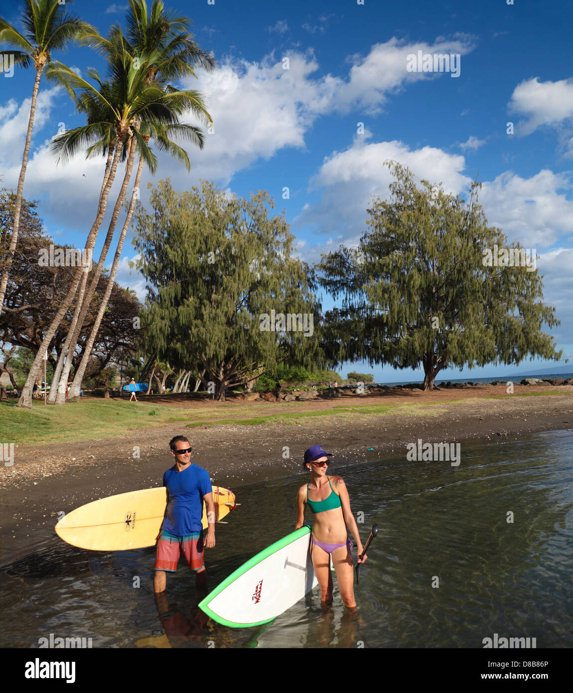 Couple with surfboard and stand up paddleboard  at Launiupoko State Wayside Park just south of Lahaina in West Maui Stock Photo