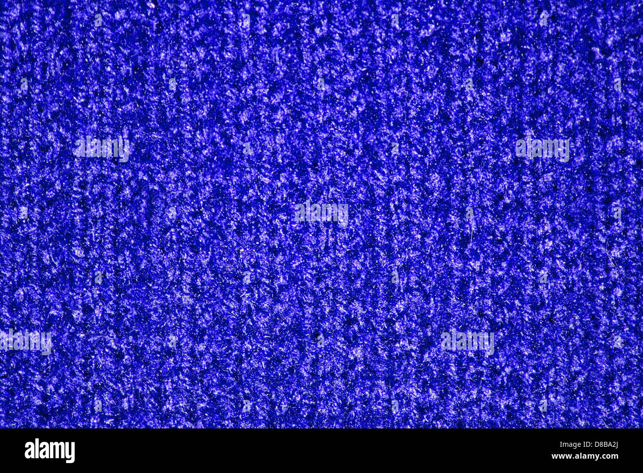 This image displays a close-up view of a blue knitted fabric ...