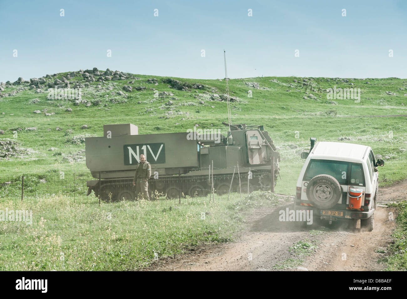 Golan Heights, Israel. A civilian jeep passes near a Multiple Launch Rocket System (MLRS) artillery launcher. Stock Photo