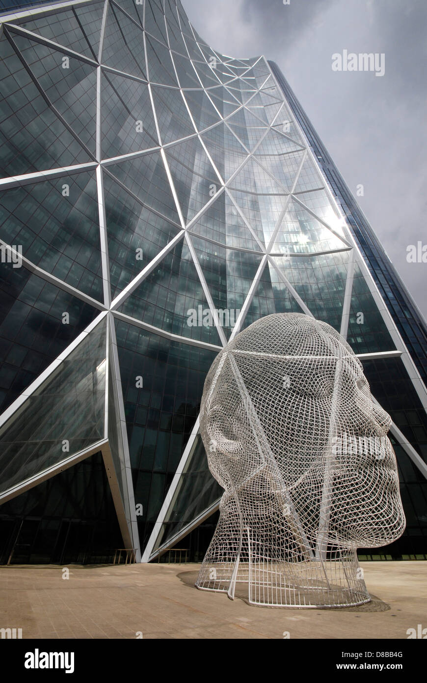 A twelve metre mesh sculpture of a young girl's head by Spanish artist Jaume Plensa stands in front of Calgary's Bow Building. Stock Photo