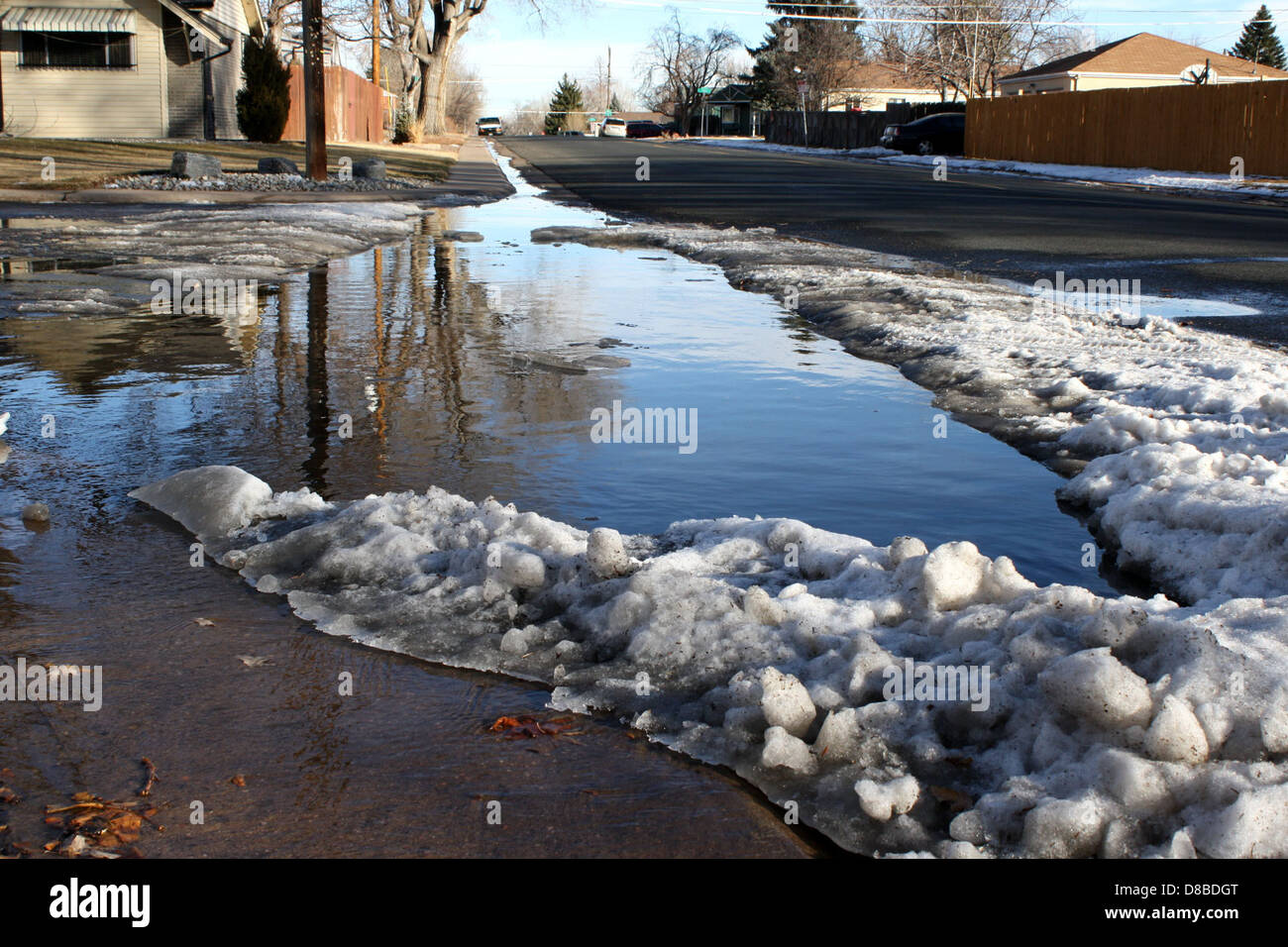 A flooded street corner after a heavy rainstorm, with standing water ...