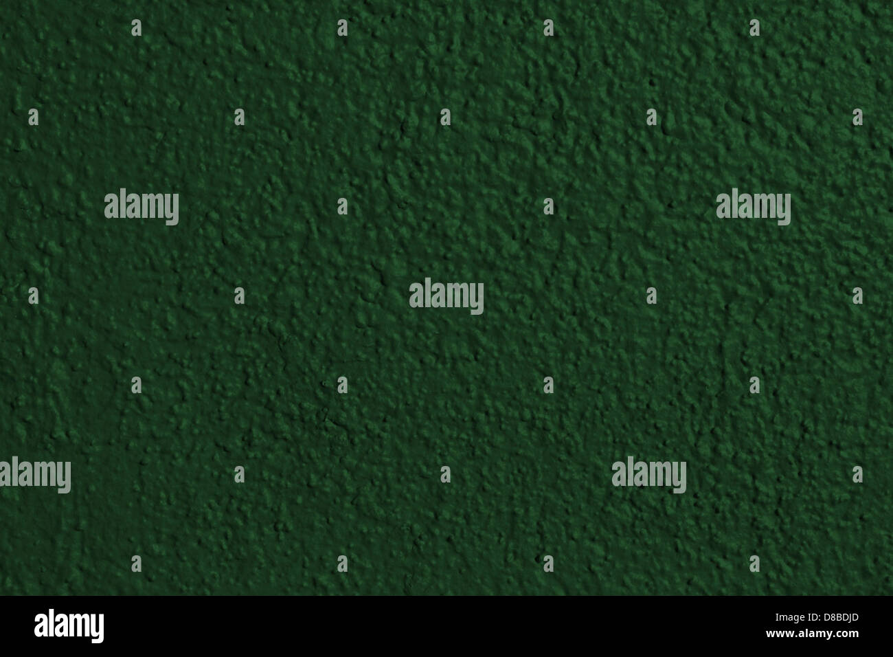 A close-up view of a forest green painted wall, showcasing the smooth, matte texture. The deep ...