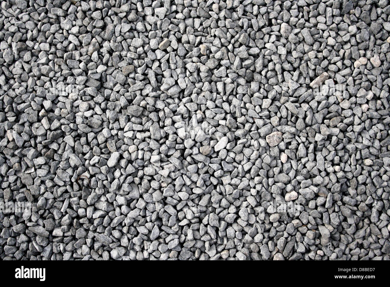 This image shows a close-up of gray gravel rocks, with their rough ...