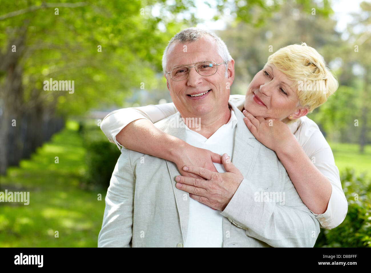Portrait of happy mature woman hugging her husband outside Stock Photo