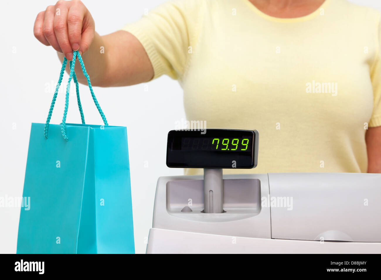 A female sales assistant giving you your purchase in a bag. Stock Photo