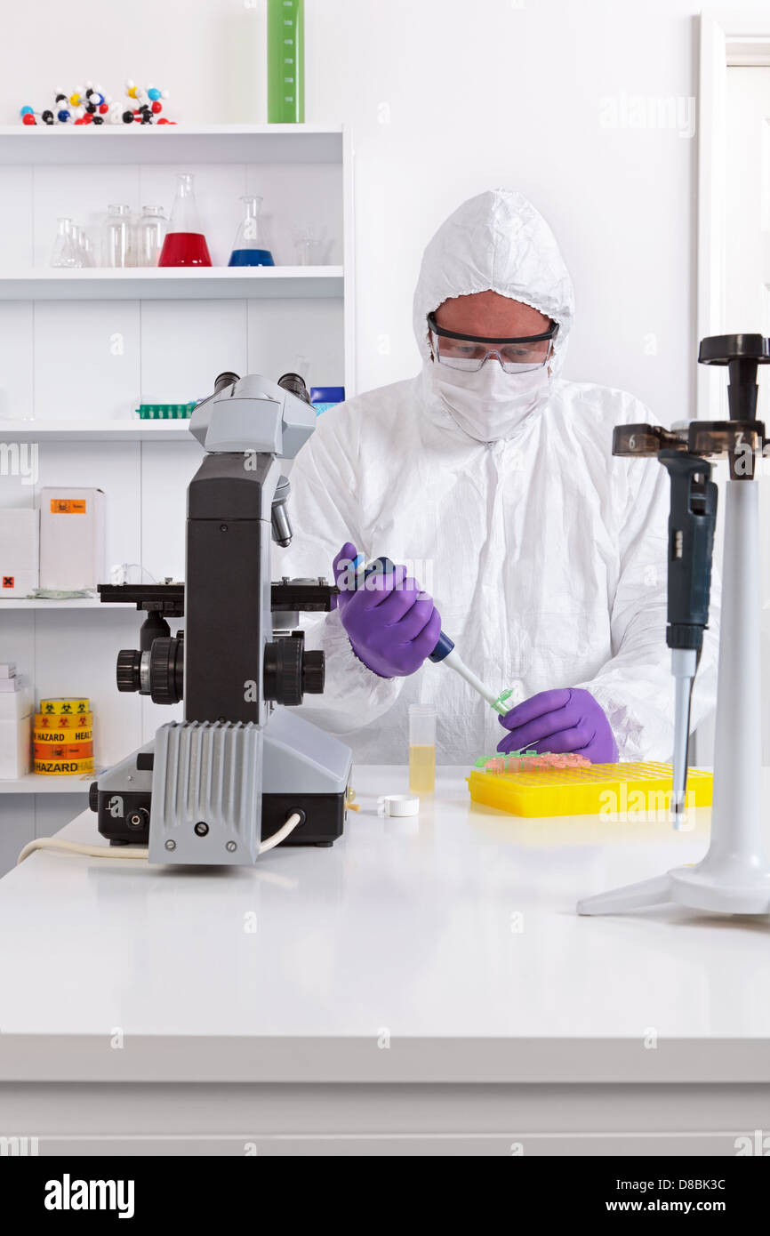 A lab technician in sterile clothing using a pipette Stock Photo