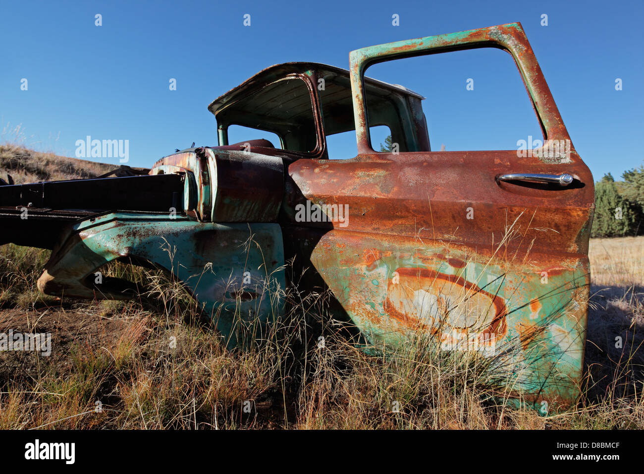 Wreck of a rusty old pickup truck out in the field Stock Photo