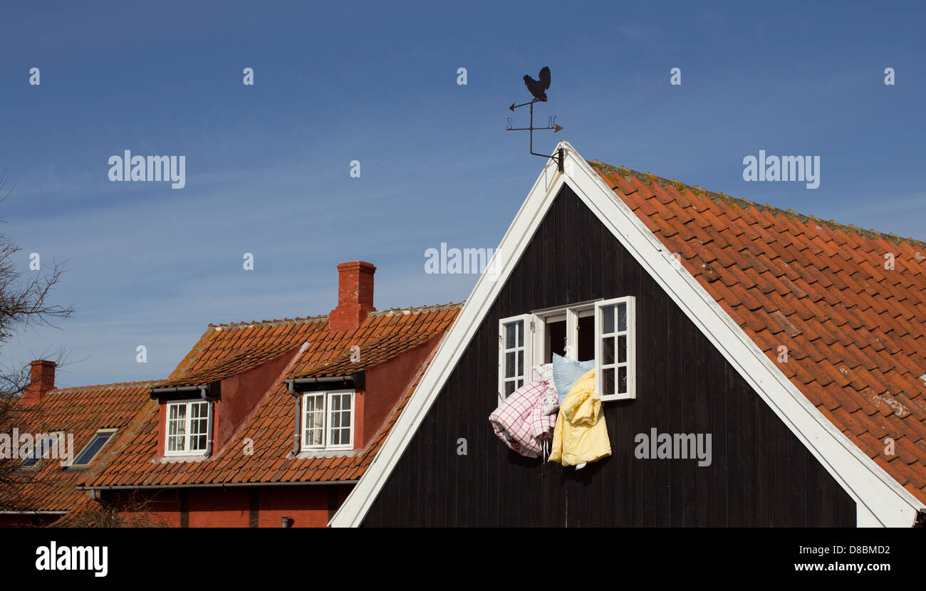 Bedclothes are being aired in a window on Bornholm, Denmark Stock Photo