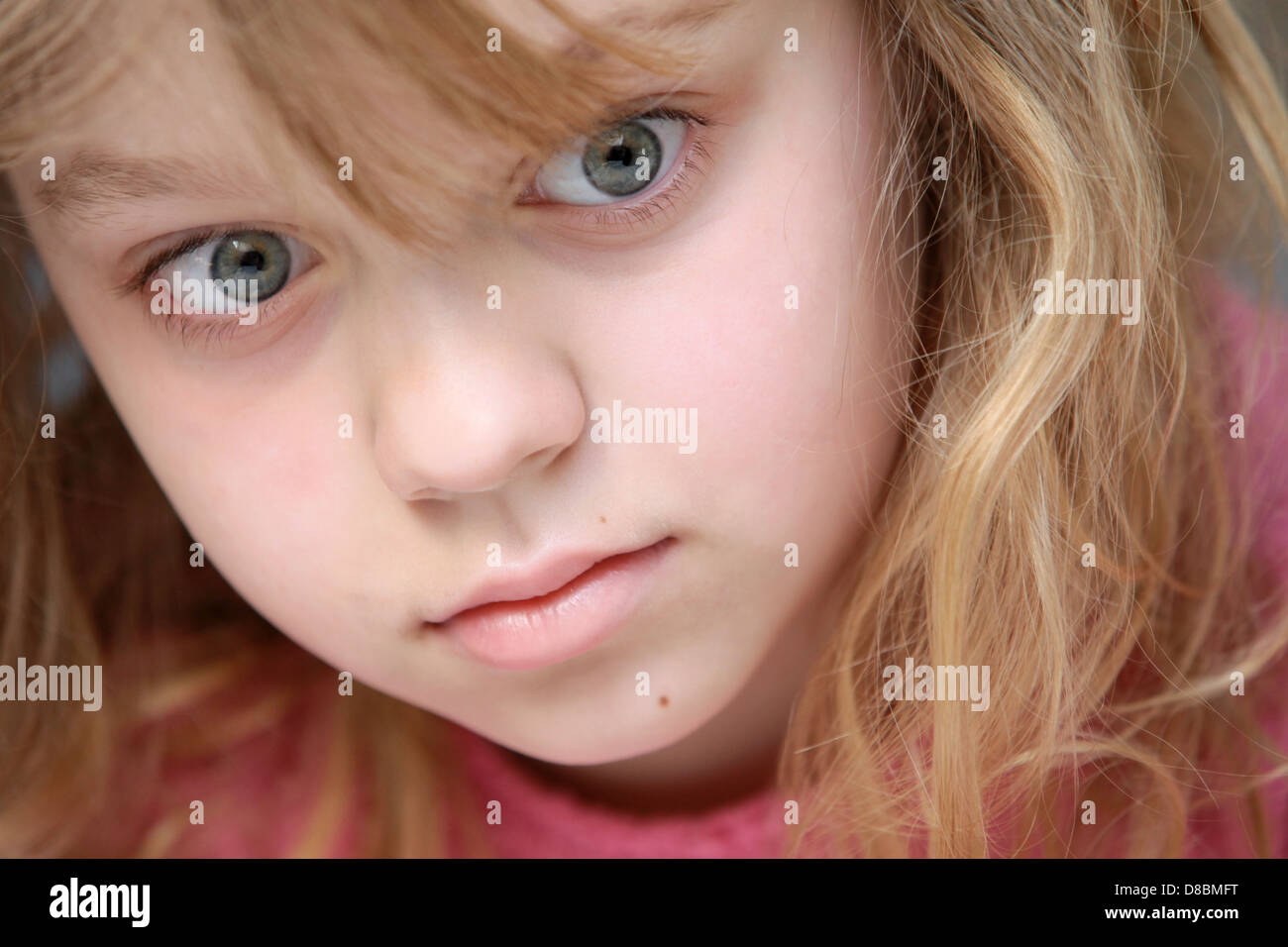 Closeup portrait of little blond Caucasian girl in pink Stock Photo