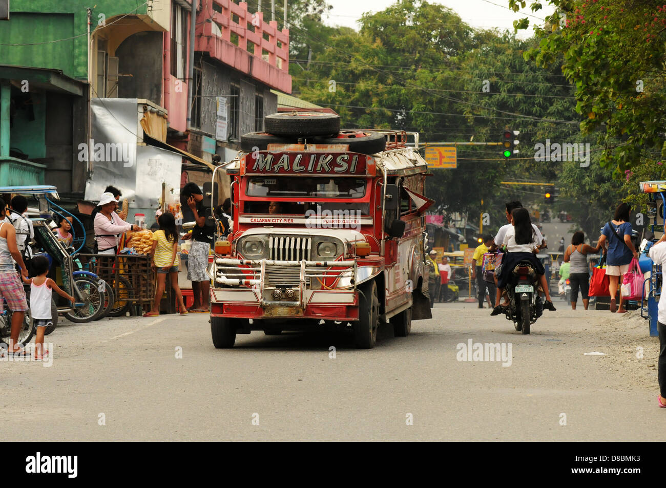 Jeepney, tricycles, motorbikes and Filipino people on the road in the