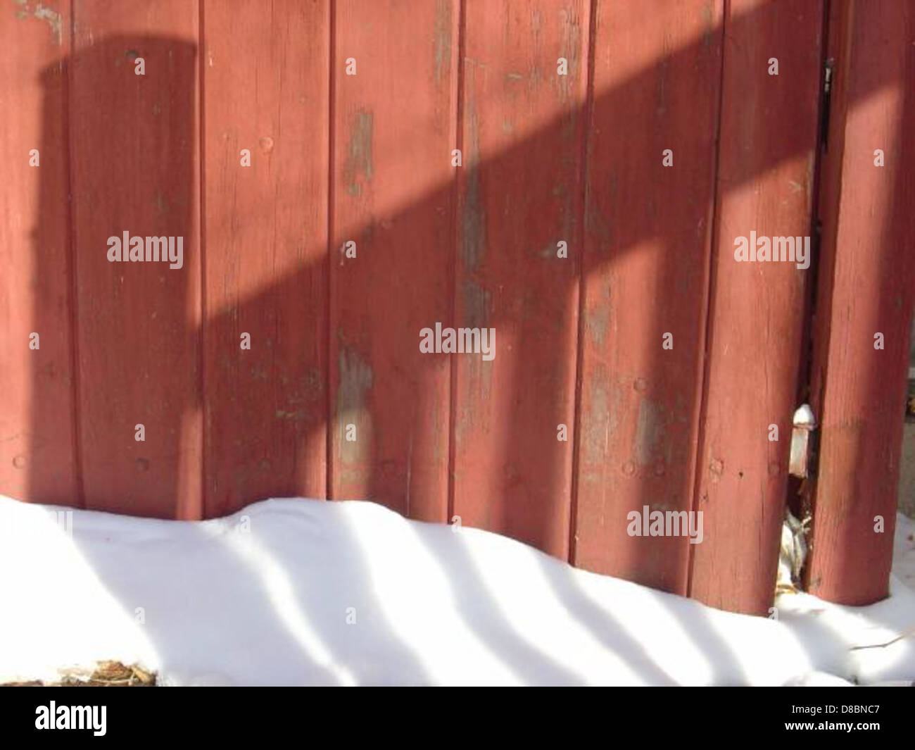 Shadows stretch across a snow-covered landscape, creating a dramatic ...