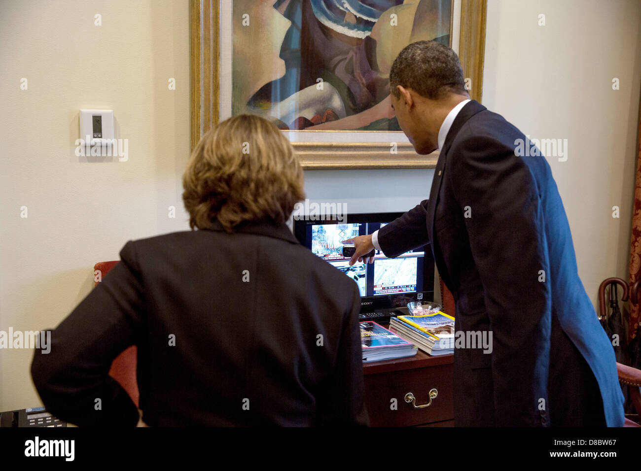 US President Barack Obama watches television coverage of the Boston Marathon bombings with Lisa Monaco, Assistant to the President for Homeland Security and Counterterrorism in the Outer Oval Office of the White House April 15, 2013 in Washington, DC. Stock Photo
