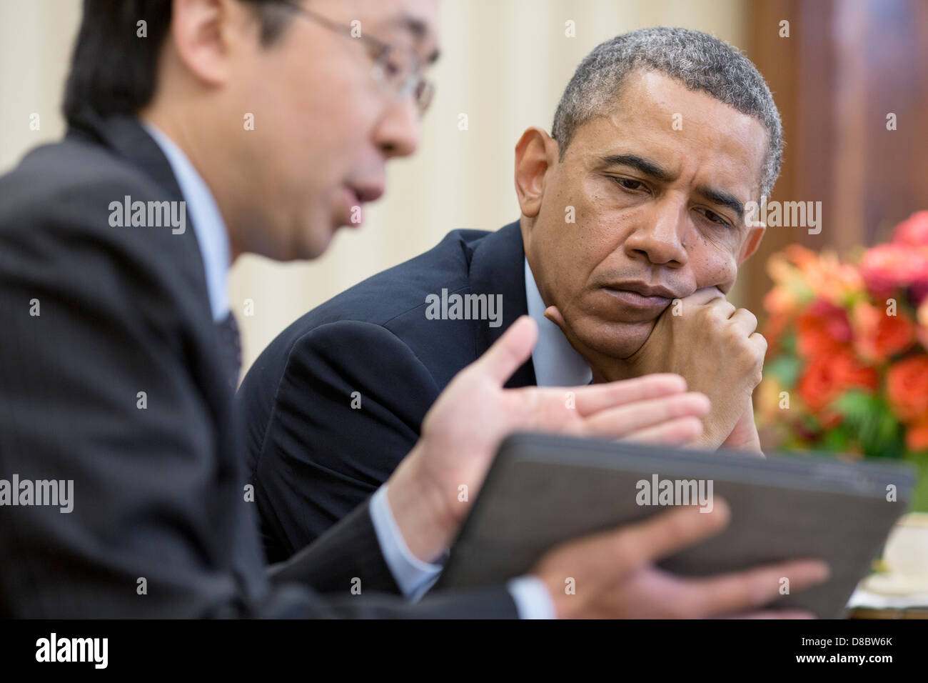 US President Barack Obama watches as Todd Park, Assistant to the President and Chief Technology Officer, shows him information on a tablet during a meeting in the Oval Office April 15, 2013 in Washington, DC. Stock Photo