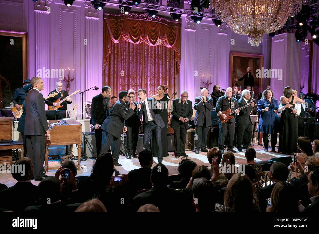 US President Barack Obama and First Lady Michelle Obama join musicians on stage during the finale of the “In Performance at the White House: Memphis Soul” concert in the East Room of the White House, April 9, 2013 in Washington, DC. The program included performances by Alabama Shakes, William Bell, Steve Cropper, Eddie Floyd, Ben Harper, Queen Latifah, Cyndi Lauper, Joshua Ledet, Sam Moore, Charlie Musselwhite, Mavis Staples, Justin Timberlake, and Booker T. Jones. Stock Photo