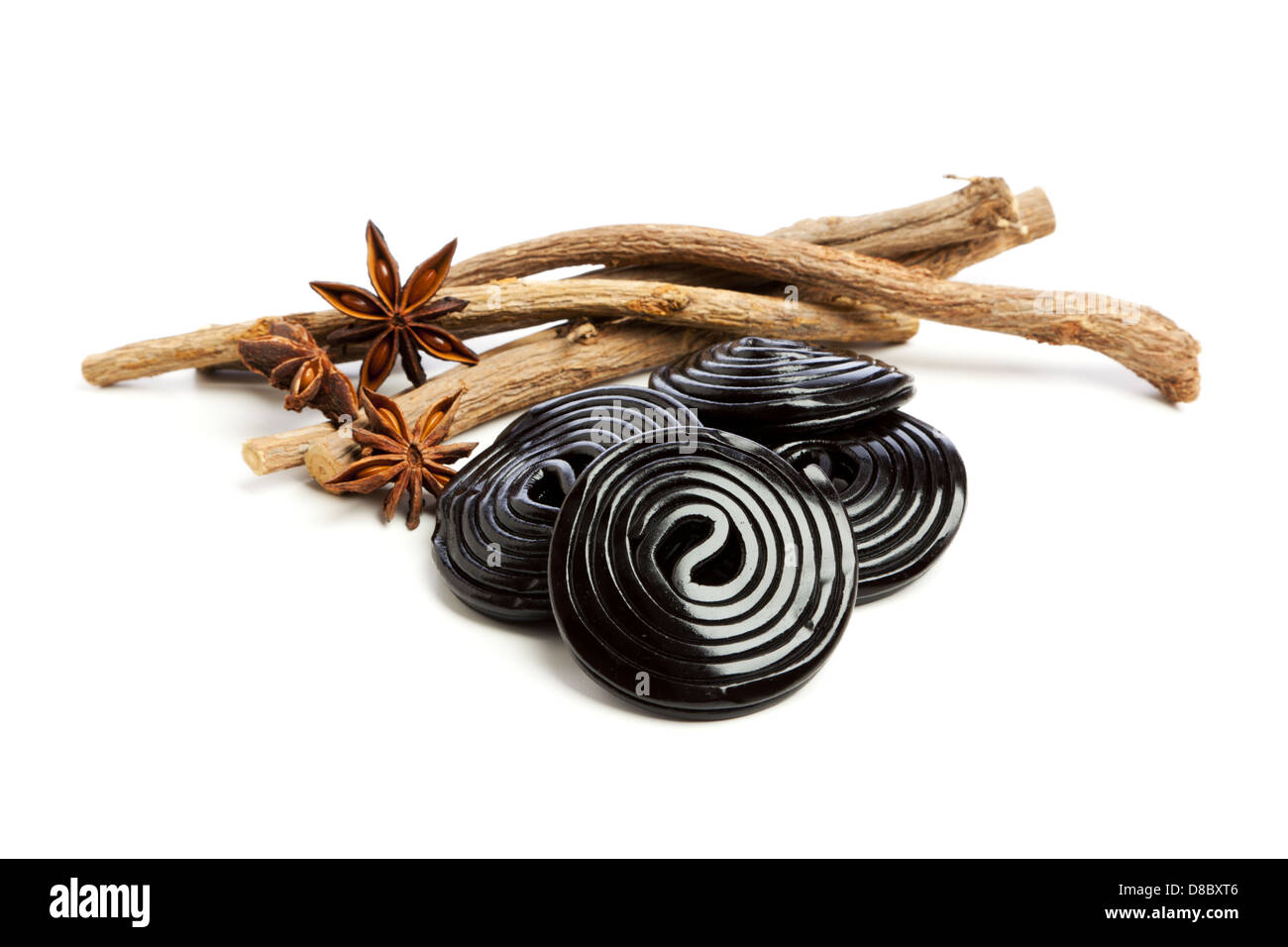 Liquorice roots, star anise and liquorice wheels on white background