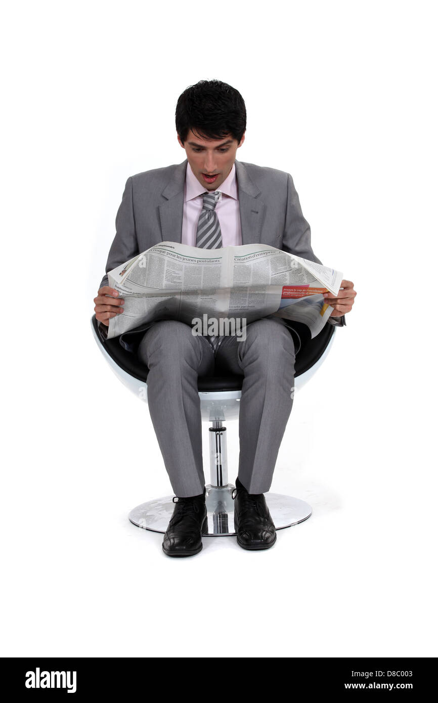 Businessman looking at a newspaper Stock Photo