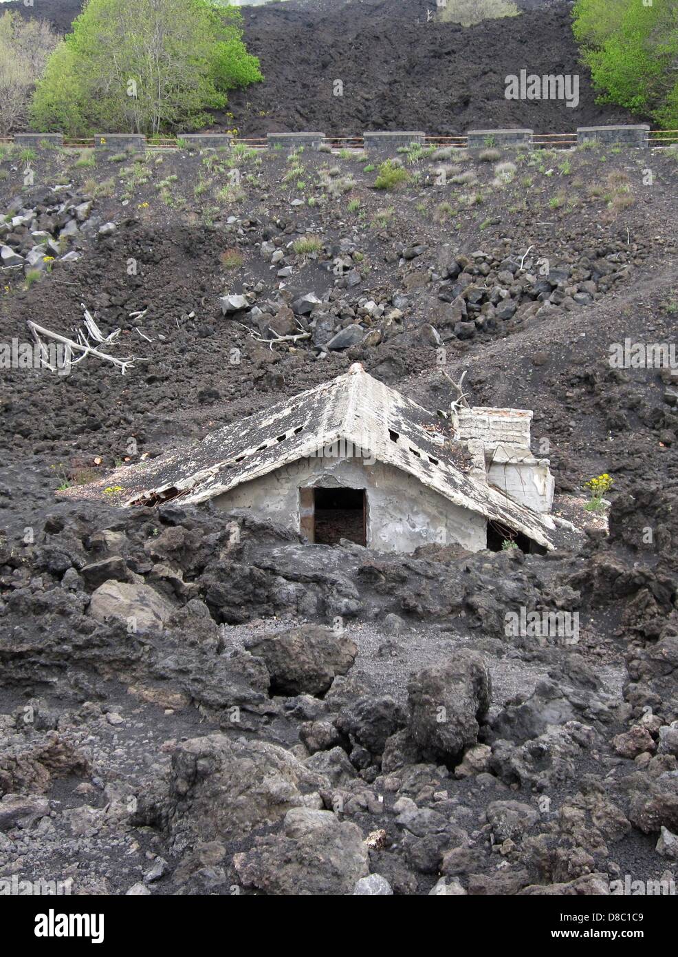 A house is covered with cooled lava from Mount Etna near Zafferana Etnea, Sicily, Italy, 07 May 2013. With a height of 3,323 meters, Mount Etna is Europe's tallest and most active volcano. Photo: JENS KALAENE Stock Photo