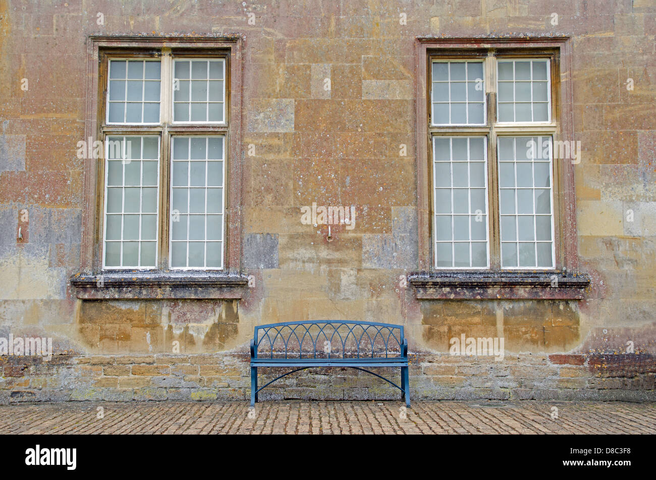 Empty iron bench on cobblestones against Bath stone facade Stock Photo