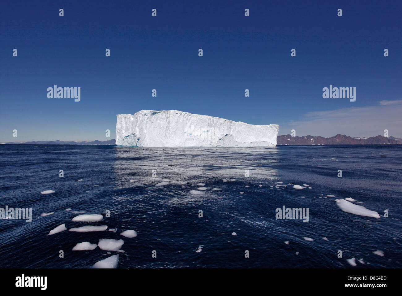 Großer Eisberg mit treibendem Eis im Vordergrund, in der Nähe von Kulusuk, Grönland Stock Photo