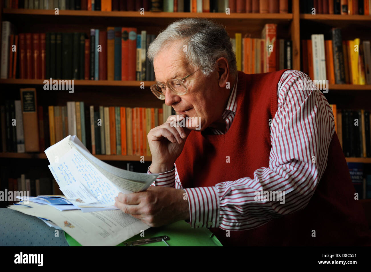 A retired man reading his archive of traditional paper correspondence UK Stock Photo