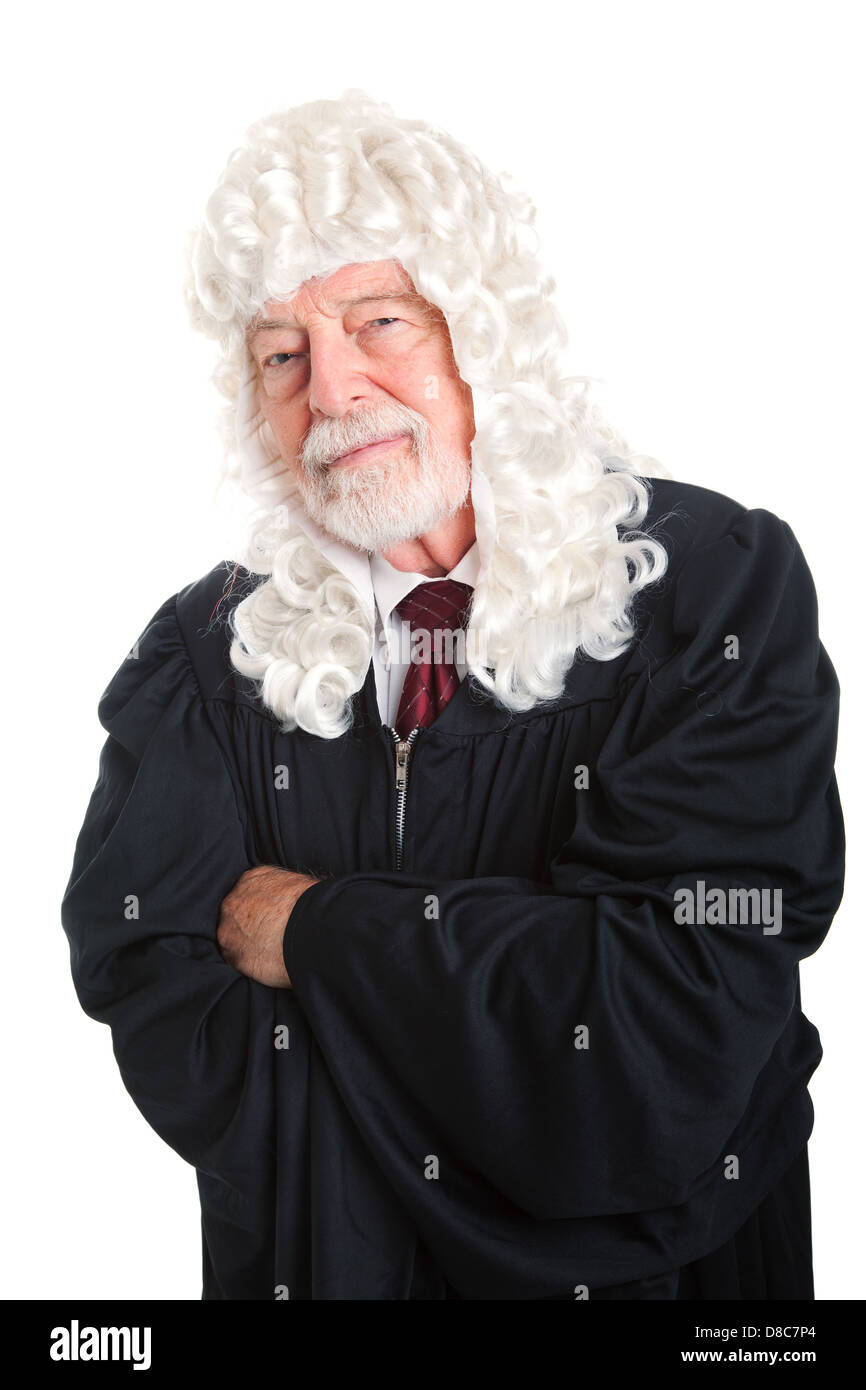 British style judge, in a wig, with his arms crossed and a skeptical expression. Isolated.  Stock Photo