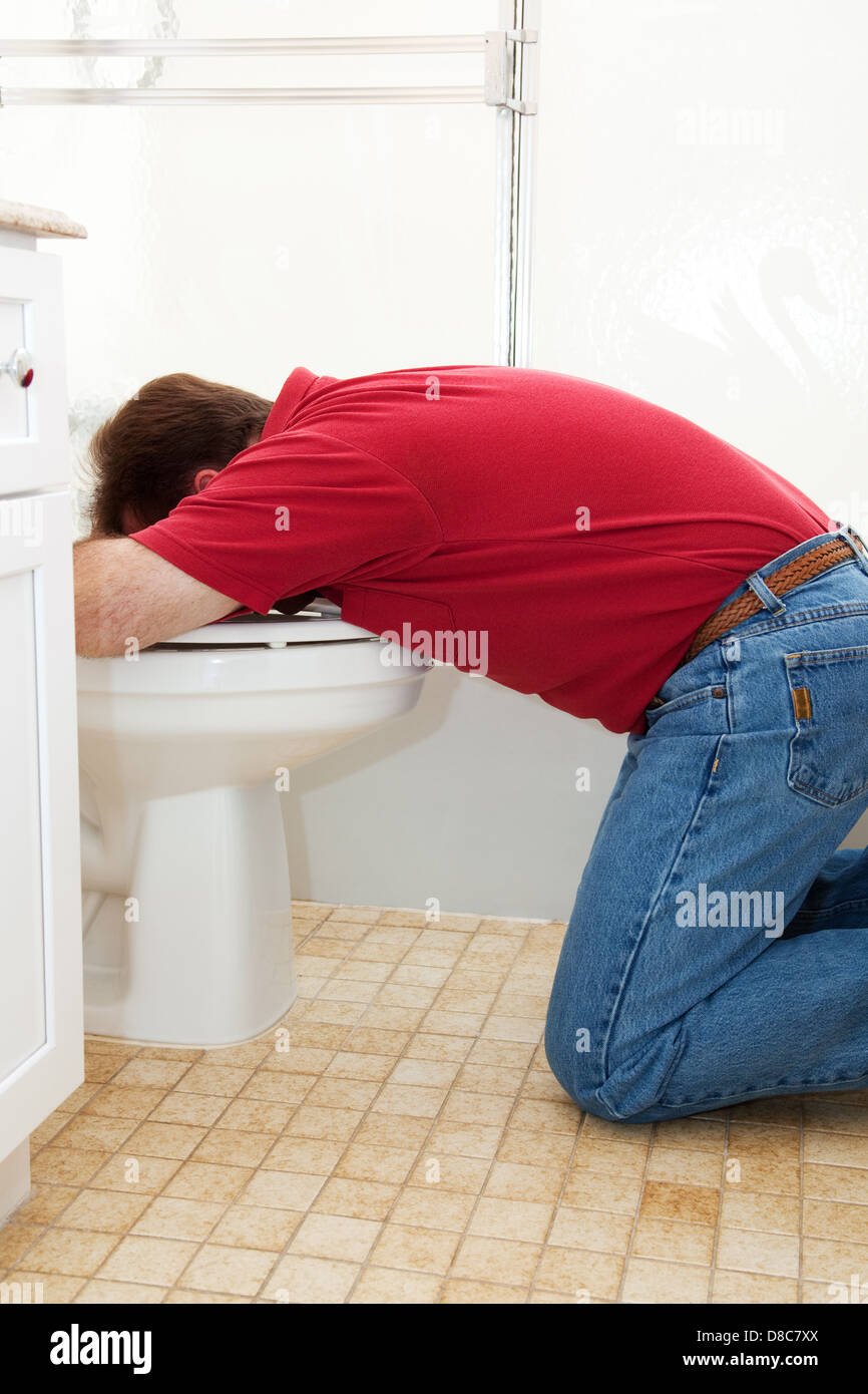 Man in the bathroom, vomiting into the toilet Stock Photo Alamy