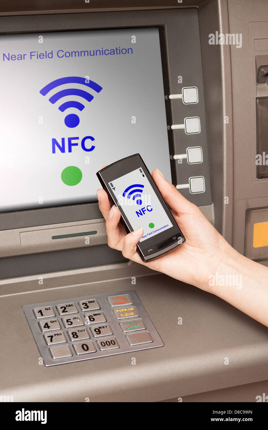 withdrawing money from atm with a mobile phone a NFC terminal Stock Photo