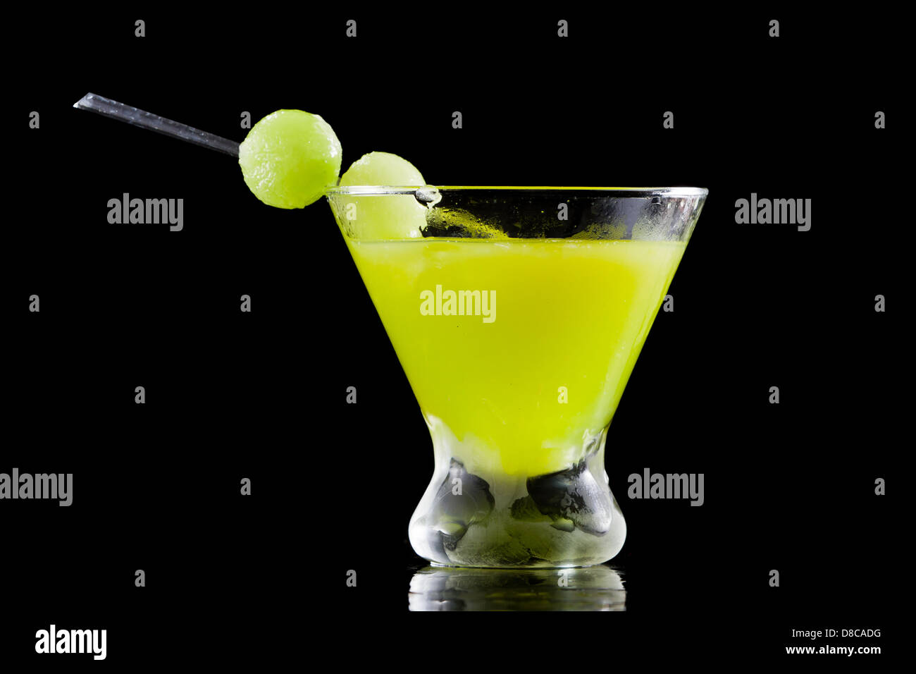 melon ball cocktail served in a stemless martini glass isolated on a black background Stock Photo