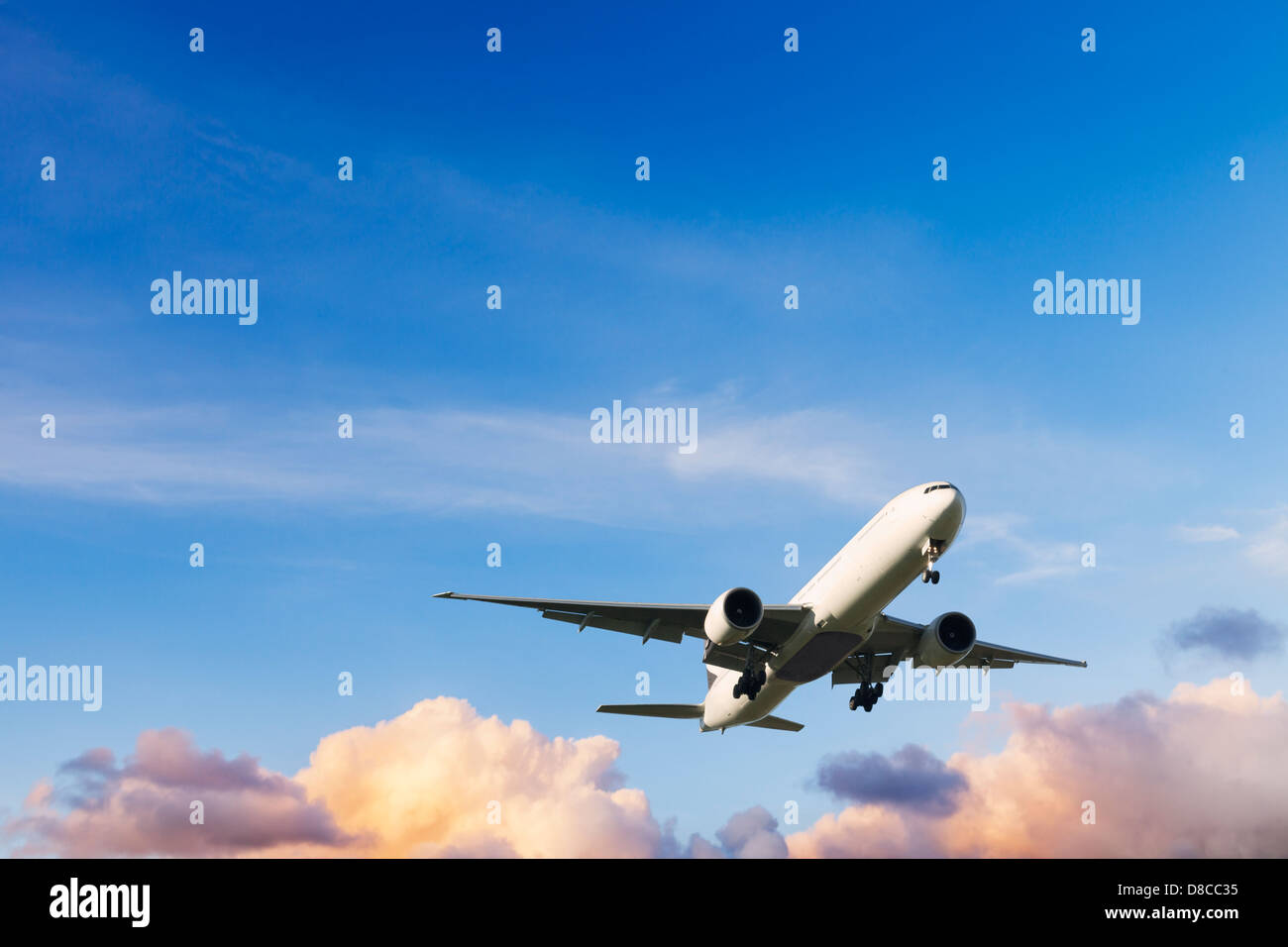 Plane - Boeing 777 coming in to land at sunset. Stock Photo