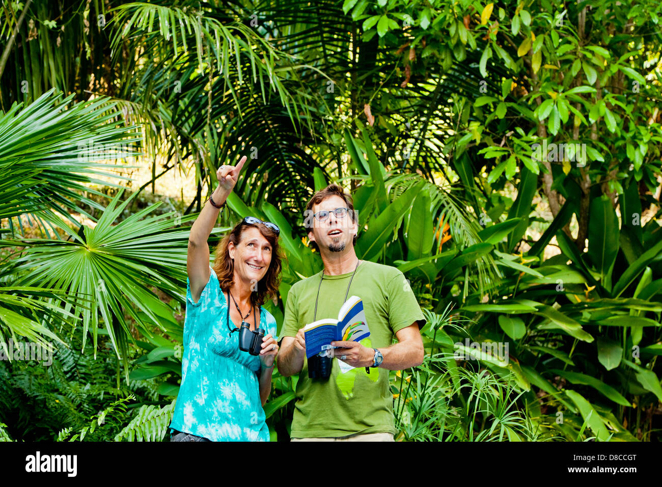 Man and woman bird watching in jungle Stock Photo