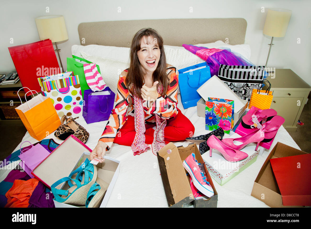 Woman on bed surrounded by shopping bags Stock Photo Alamy
