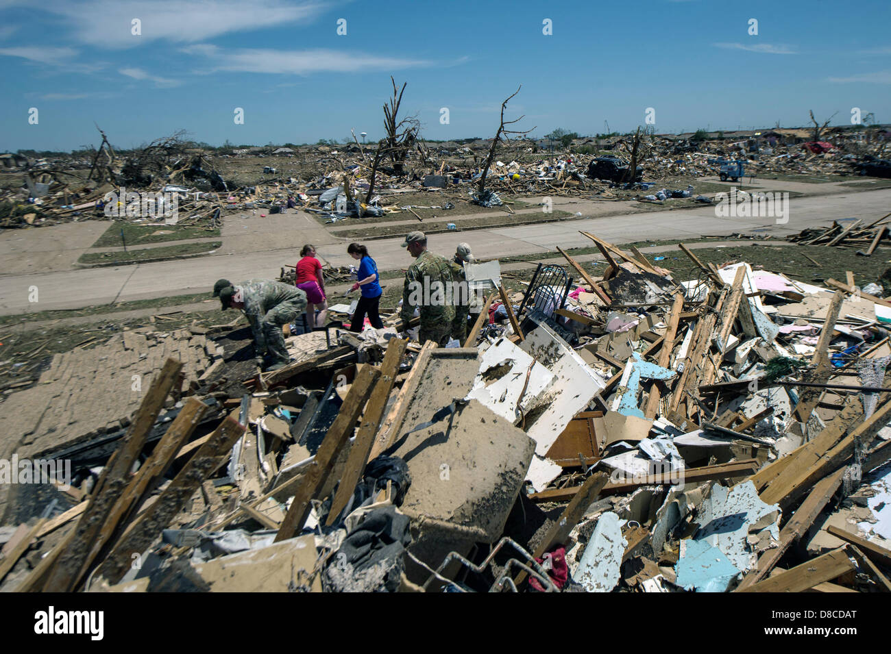 Air Force personnel help residents sift through the wreckage of their homes in the aftermath of an EF-5 tornado May 22, 2013 in Moore, Oklahoma. The massive storm with winds exceeding 200 miles per hour tore through the Oklahoma City suburb May 20, 2013, killing at least 24 people, injuring more than 230 and displacing thousands. Stock Photo