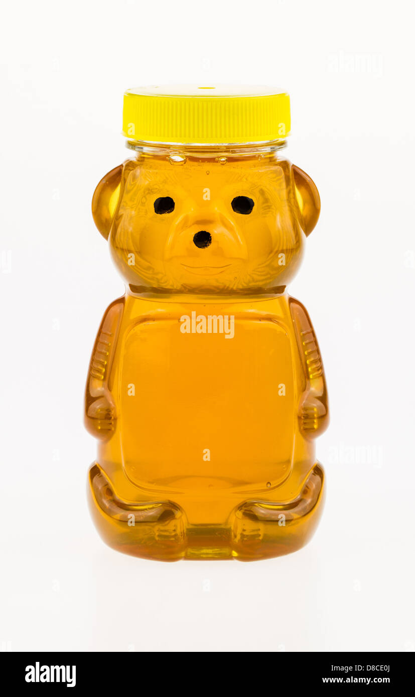 Sweet golden honey in a plastic bear shaped container. Stock Photo
