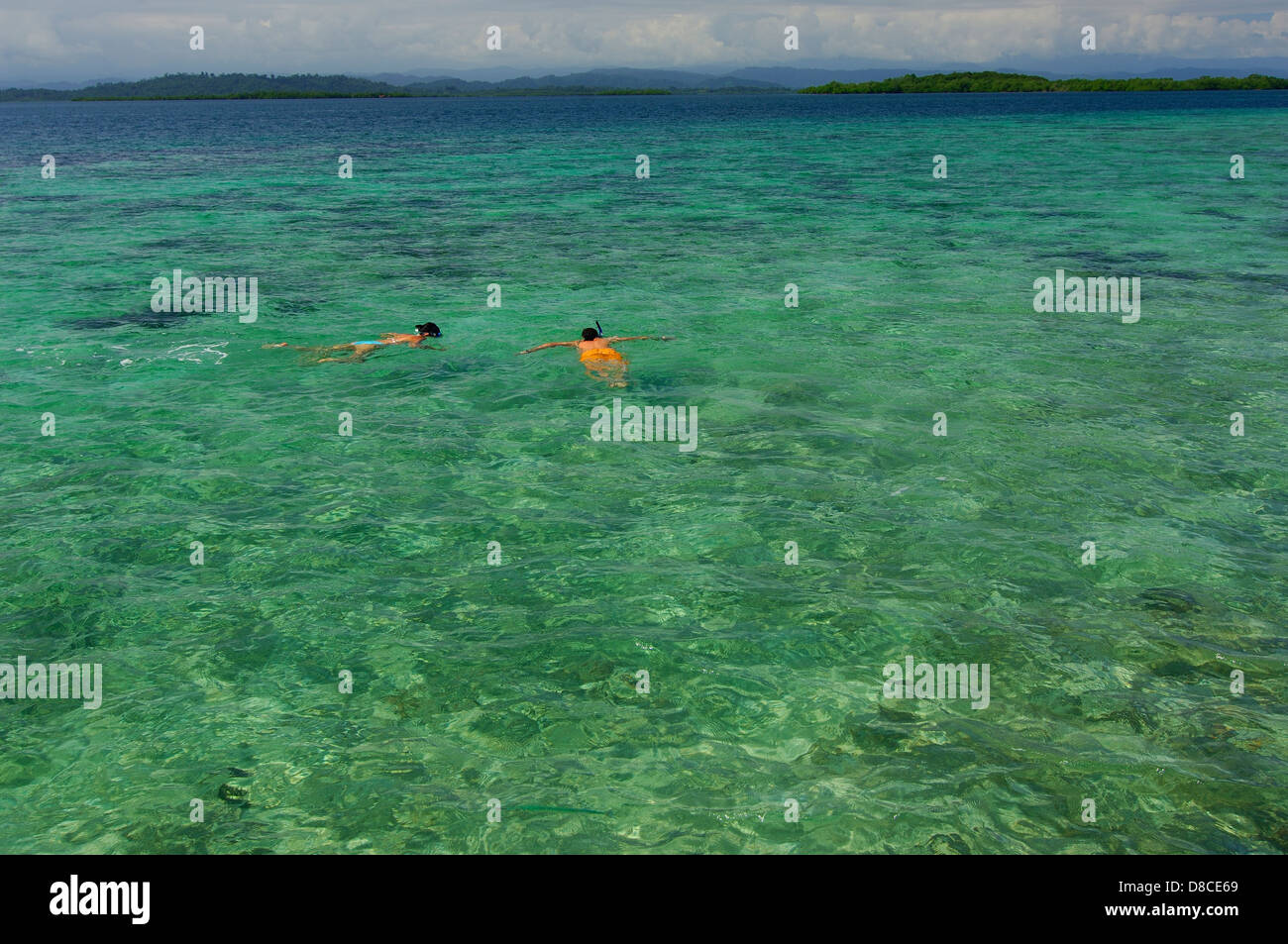 Man and woman doing snorkeling in clear waters at Colon Island shore Stock Photo