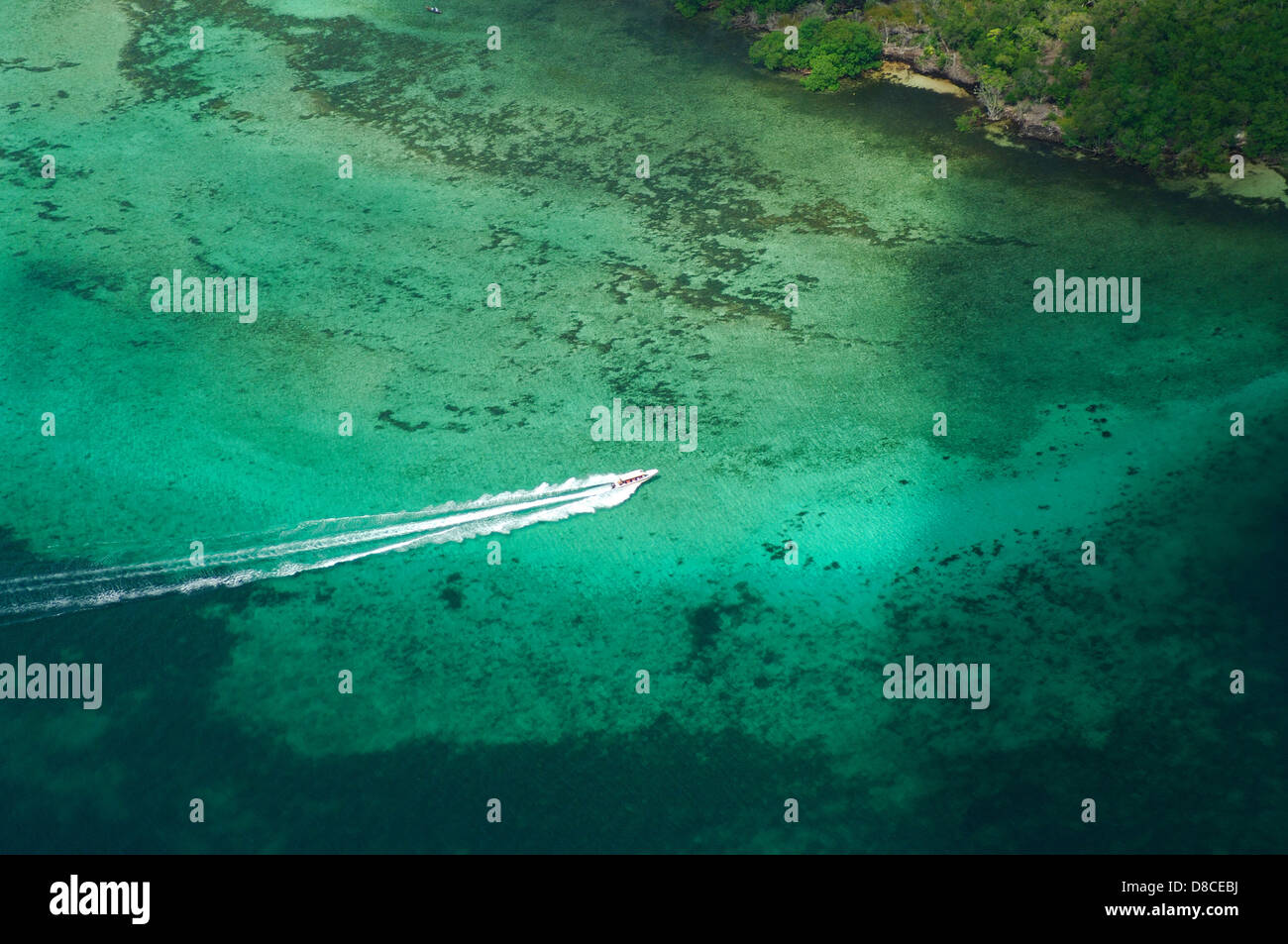 Aerial view of motor boat navigating over reef near the shore Stock Photo