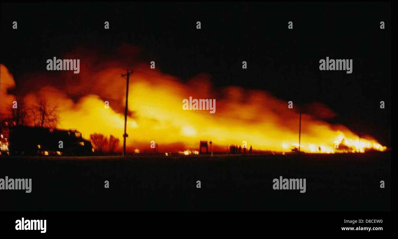 This image shows a large fire burning at night. The fire’s bright flames are visible against the dark sky, illustrating the intensity and scale of the blaze. Stock Photo