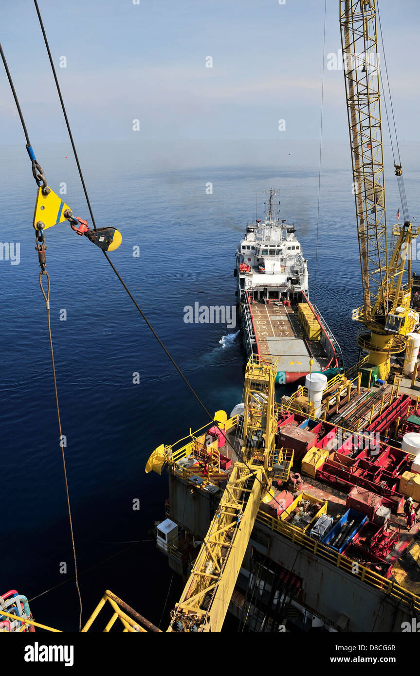 Oil rig and docked loading ship Stock Photo - Alamy