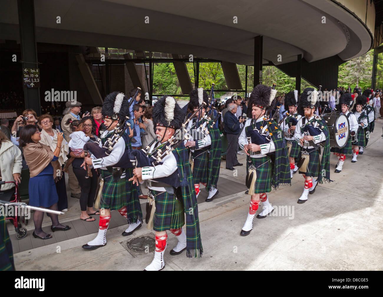 A marching band including bagpipes and drums celebrates a graduation at