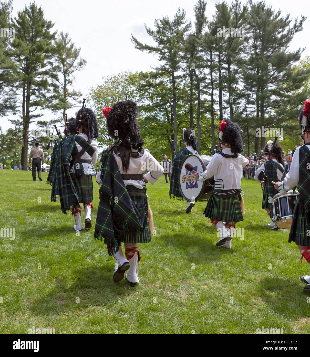 A marching band including bagpipes and drums celebrates a graduation at