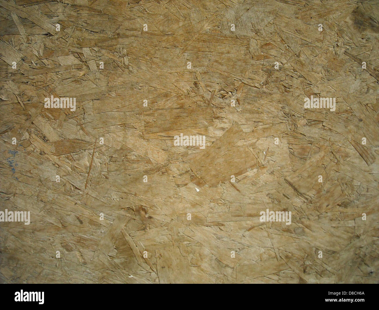 This image shows a close-up of chipboard, a manufactured wood product ...